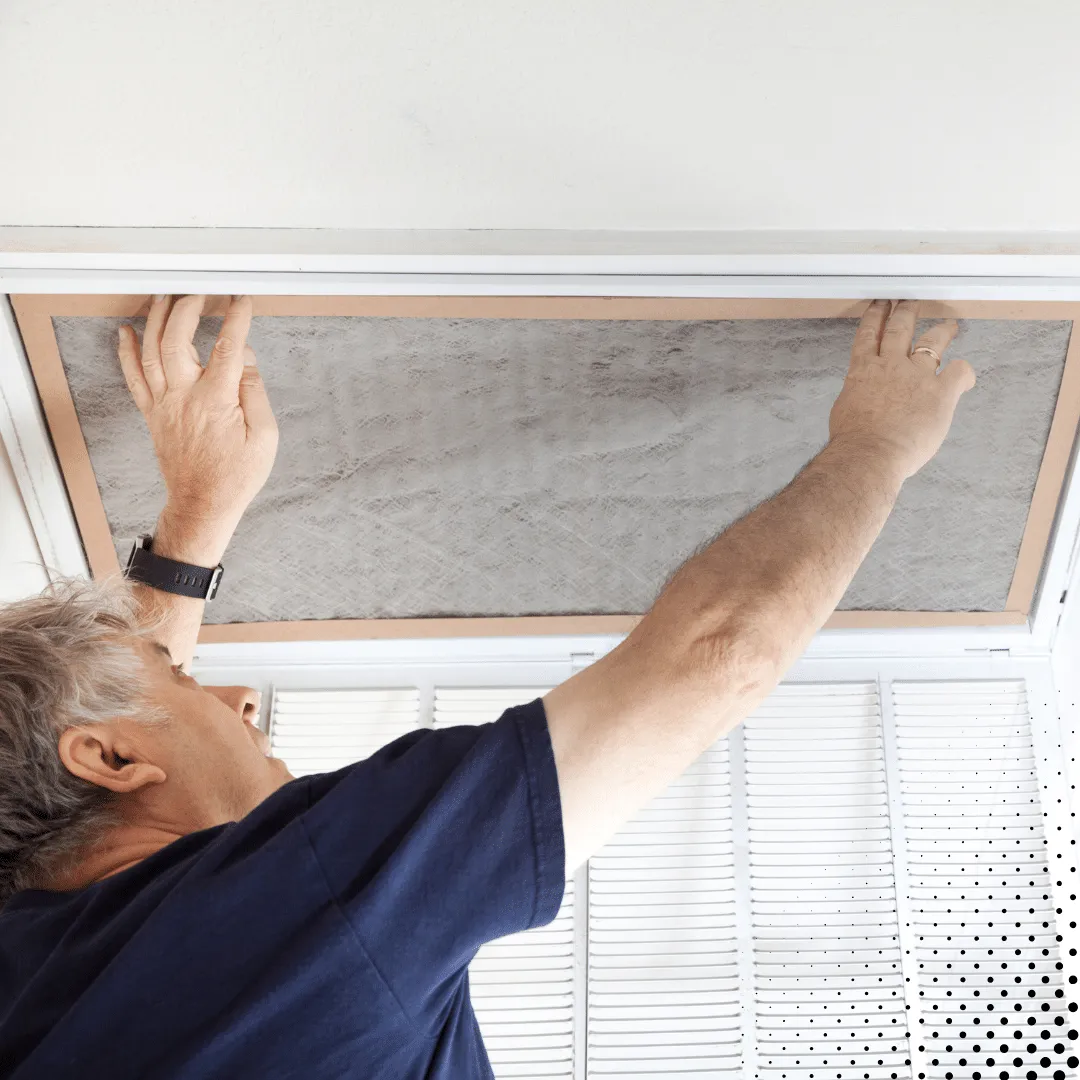 Homeowner replacing HVAC air filter as part of new year home maintenance goals