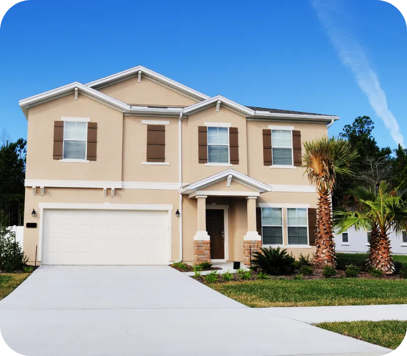 Two-story beige home in St. Cloud, Florida with palm trees and a clean driveway under a bright blue sky, representing inspected Central Florida properties.