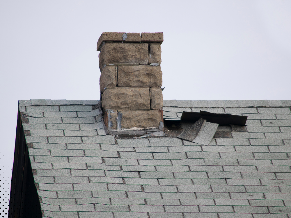 Damaged shingles around a chimney. Damaged shingles around a chimney.