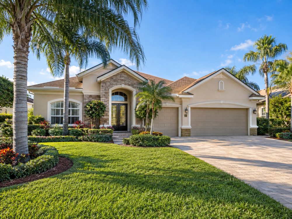 Single-story Central Florida home with a stone entry, three-car garage, paver driveway and palm trees on a sunny day, the kind of house being prepared to list