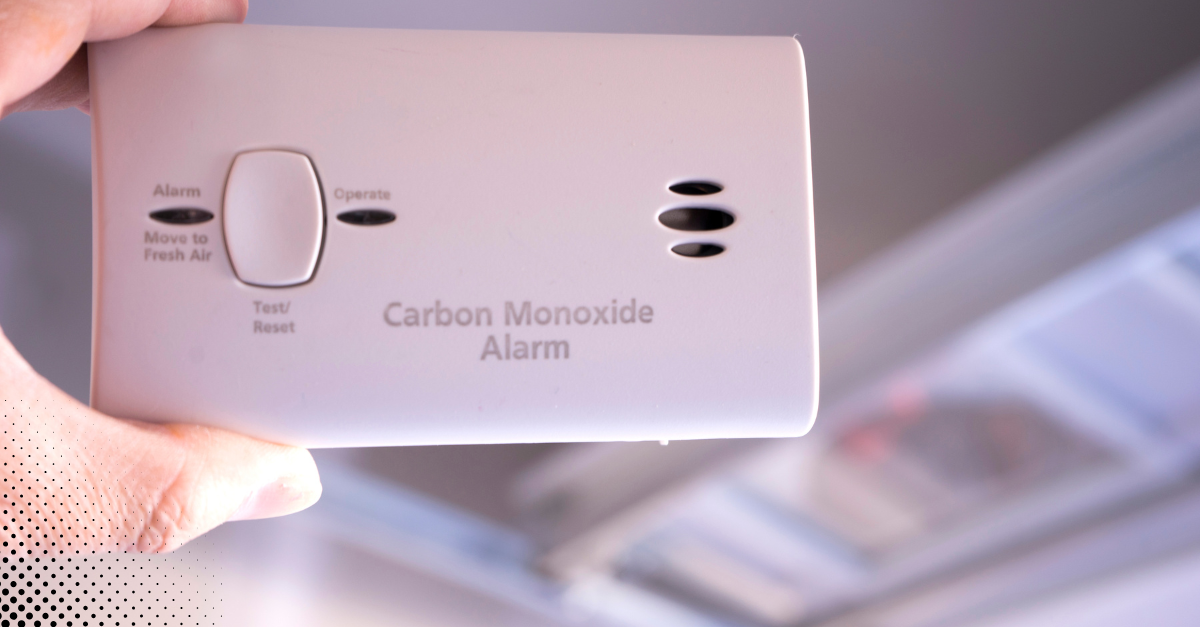 Carbon monoxide alarm sitting on top of a home blueprint.