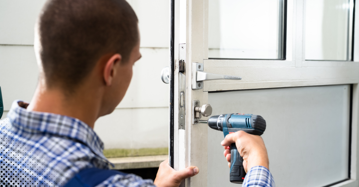 Homeowner using drill to adjust or secure exterior door hardware.